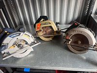 Three circular saws lined up on shelf: Mastercraft on left, Craftsman in middle, SKIL on right