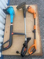 Top view of three electric weed whackers showing colors and general condition