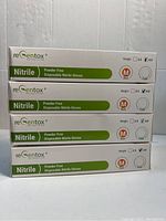 Four boxes of reGentox powder free disposable nitrile gloves, medium size, white color. Each box weighs 3.5 oz and contains gloves for single use.