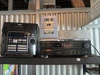 Photo showing various stereo system components including Denon AVR-900 receiver, RCA stereo unit, and silver speaker.