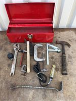 Photo showing the full open red metal toolbox and all included tools laid out on surface.
