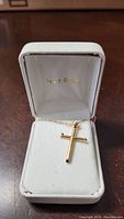 10k gold cross pendant and chain displayed in white box stamped '14 KT. GOLD'