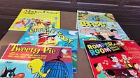 Overview of six vintage children's LP records from 1950s and 1960s with colorful illustrated covers including Mother Goose, Little Toot, Popeye, Tweety Pie, and Romper Room.