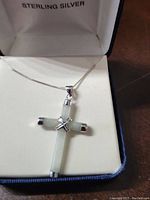 Front view of the 925 sterling silver cross pendant necklace with light stone inlay displayed in a jewelry box with 'Sterling Silver' label.