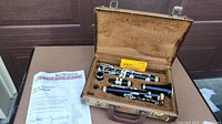 Opened hard case with Yamaha B-flat clarinet assembled in parts, Ricco reed box, mouthpiece, and Yamaha Band Student documentation placed beside.