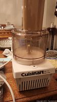 Full view of the Cuisinart food processor base and attached clear work bowl with feed tube.