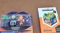 Photo of boxed Minecraft figures and Minecraft Guide to Survival book on table