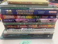 Photo showing 12 stacked gardening books with titles visible