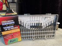 Photo showing the closed plastic case containing 16 precision screwdrivers with a colorful pamphlet in front describing the set's contents and Duramax branding.