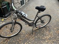 Full side view of grey Infinity bicycle with 21 speed gears, black gel seat, and bottle holder on handlebars.