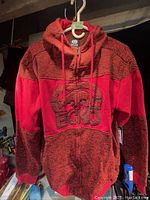 Front view of the red and black marled Ecko Unltd hoodie, showing zipper, hood, and large embroidered logo on chest.