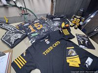 Wide photo of Hamilton Tiger-Cats kid's jersey, foam finger, doll, T-shirts, booklet, and other merchandise