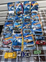 Group photo of 17 Hot Wheels cars in blister packaging and 2 loose cars in front