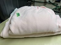 Image showing folded pink flannelette sheets, showcasing soft texture and light pink color.