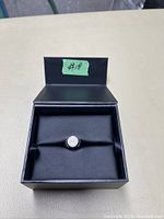 Ring inside original black box with a green label marked #18 on the box lid