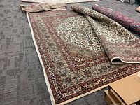 Overview of rug partially unrolled showing central medallion and borders