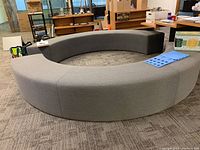 Two gray curved benches arranged concentrically on showroom floor.