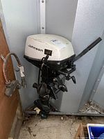 Side view of the Johnson outboard motor showing the white housing, brand name, and manual pull start handle.