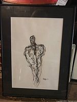 Full view of framed abstract ink drawing depicting a figure.