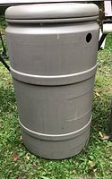 Full exterior view of gray plastic rain barrel showing cylindrical shape and reinforcing bands.