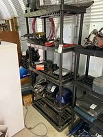 Full shelf unit filled with various power tools and other items; photo to show overall shelving unit and conditions.