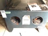 Front view of Mastercraft metal sandblaster cabinet showing dual glove ports and warning label.