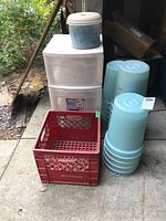 Image showing 17 blue sap buckets, red plastic milk crate, and white 3-drawer cart on castors in a shed