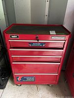 Front view of the red Mastercraft metal tool cart with five drawers, visible locking keyhole and Mastercraft branding.