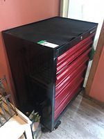 Closed tool chest viewed at an angle showing black frame and red drawers