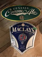Photo showing both Genesee Cream Ale and Maclays Pale Ale metal signs side by side for size and detail comparison.