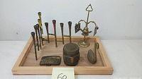 Photo showing entire collection: Jewish menorah, incense burner, belt buckle, decorative box, and swan figurine arranged on wooden tray