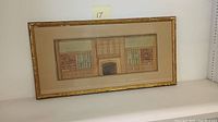 Framed architectural drawing showing hand colored interior law chambers with fireplace and shelving.