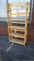 Front view of a 5-tier wooden shelving unit with slatted sides and flat shelves.