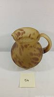 Front view of satin glass pitcher showing leopard skin pattern and shape