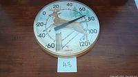 Full view of the round Sunbeam thermometer showing the deer, fence post, and temperature dial from -60 to 120 °F.