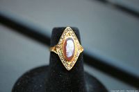 Front view showing the cameo shell carving and surrounding pearls on the 14K gold ring.