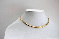 Front view of the gold plated snake style choker necklace displayed on a white fabric bust stand.