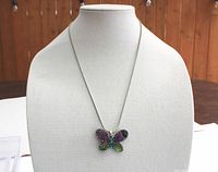 Full view of the necklace displayed on a mannequin bust showing the complete chain and butterfly pendant.