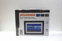Front view of the Sylvania 10 inch digital photo frame box showing brand, screen size, and features.