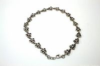 Full view of sterling silver flowered ankle bracelet arranged in a circle showing design and clasp