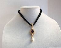 Full view of black velvet choker necklace displayed on mannequin, showing pendant hanging at center