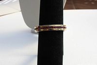 Front view of gold-plated bracelet showing the row of purple rectangular stones set in the band.