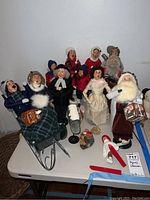 Overview of the Byers Choice Christmas Caroler figurines showing a variety of standing and seated figures including Santa Claus and a woman on a sled