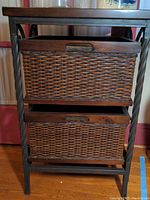 Front view of the storage cubby showing the two wicker baskets inserted and the wooden top surface.