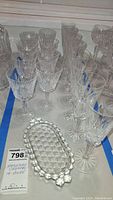 Overall view of crystal decanter, two rows of stemware, and butter dish on table