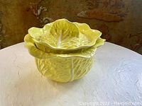 Overall view of the yellow cabbage leaf ceramic soup tureen with lid, showing the leaf detail and texture.
