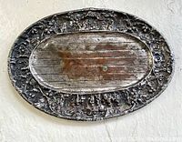Oval tray with silver border and wood center, showing wear and patina.