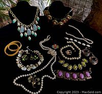 Overview of all 16 vintage jewelry pieces including necklaces, bracelets, earrings, bangles, and brooches, displayed on black velvet stands and surface.