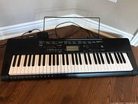 Full view of Casio CTK-3500 keyboard showing keys, power adapter, and music stand.