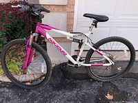 Side view of Nakamura bicycle showing white and pink frame, black tires, and front and rear suspension.